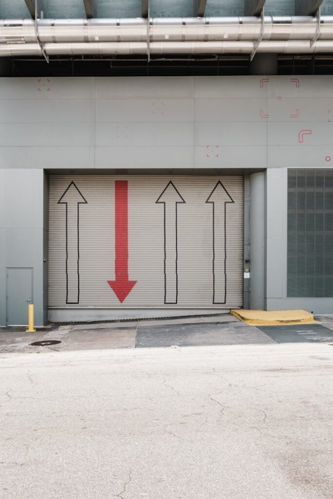 Metal shutter in industrial setting with directional arrows, urban design.
